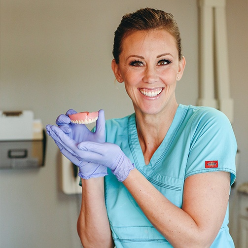 Dental team member holding a full denture