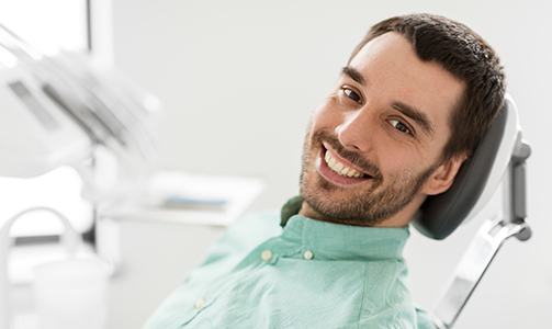 Man in dental chair smiling after root canal therapy