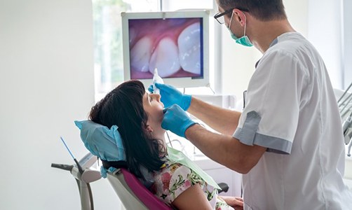 dentist showing patient their tooth using intraoral camera  