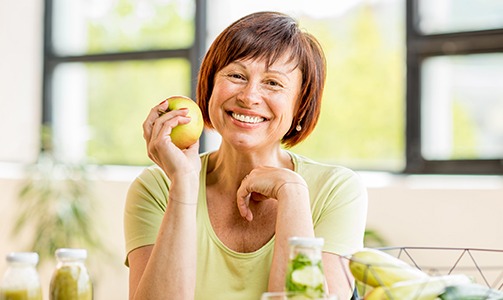 Older woman with denture holding an apple