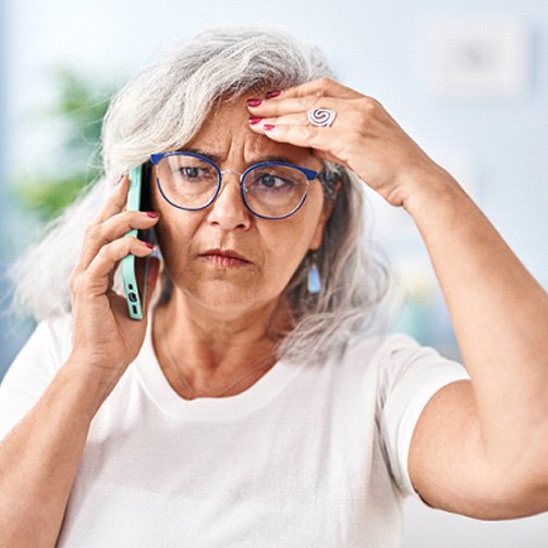 a concerned woman on the phone with an emergency dentist