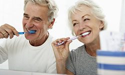 elderly couple brushing their teeth 