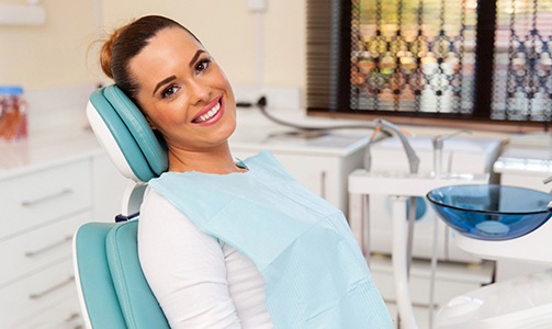 Woman smiling and leaning back in dental chair