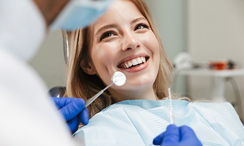Woman in dental office for tooth colored filling smiling