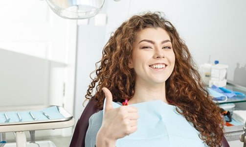 woman in the dental chair giving a thumbs-up after professional teeth whitening in Idaho Falls 